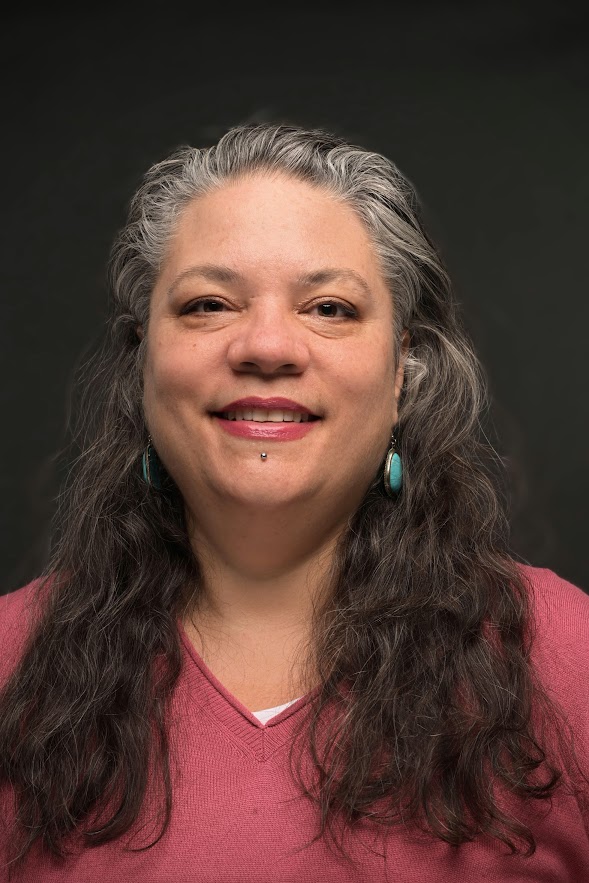 A smiling woman with long hair and a red shirt 