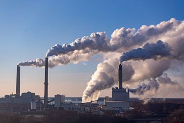 A factory's smokestacks belch pollution into the air